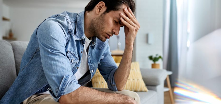 young-man-having-headache-holding-his-head-pain-home